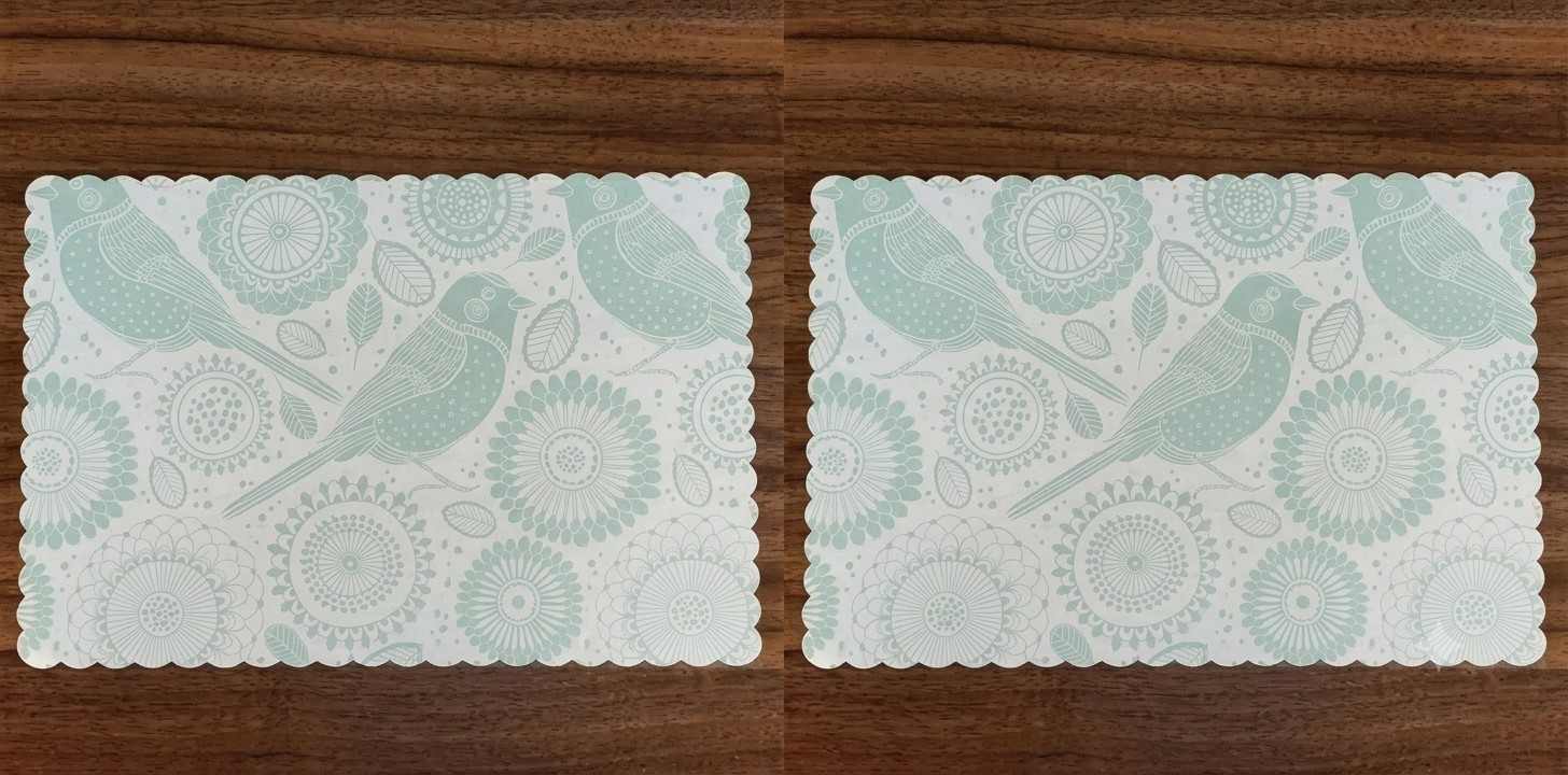 Custom printed placemats featuring decorative patterns neatly arranged on a restaurant dining table setting.